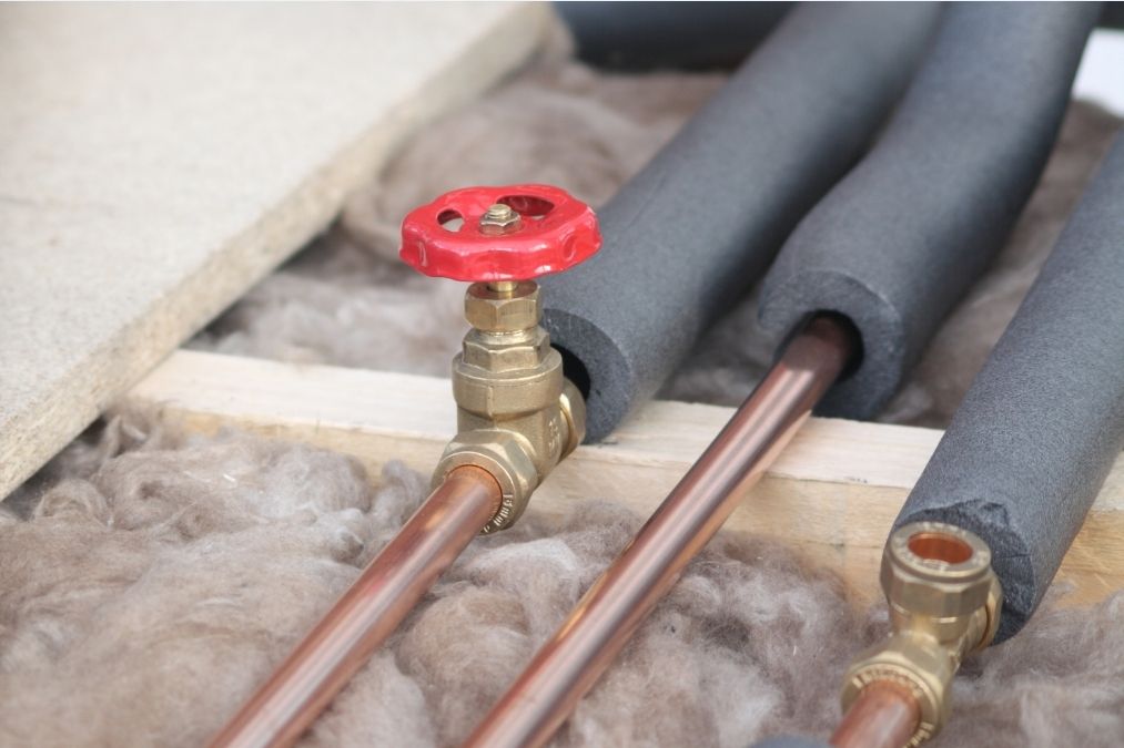 Foam insulation wrapped around crawl space pipes to prevent winter condensation