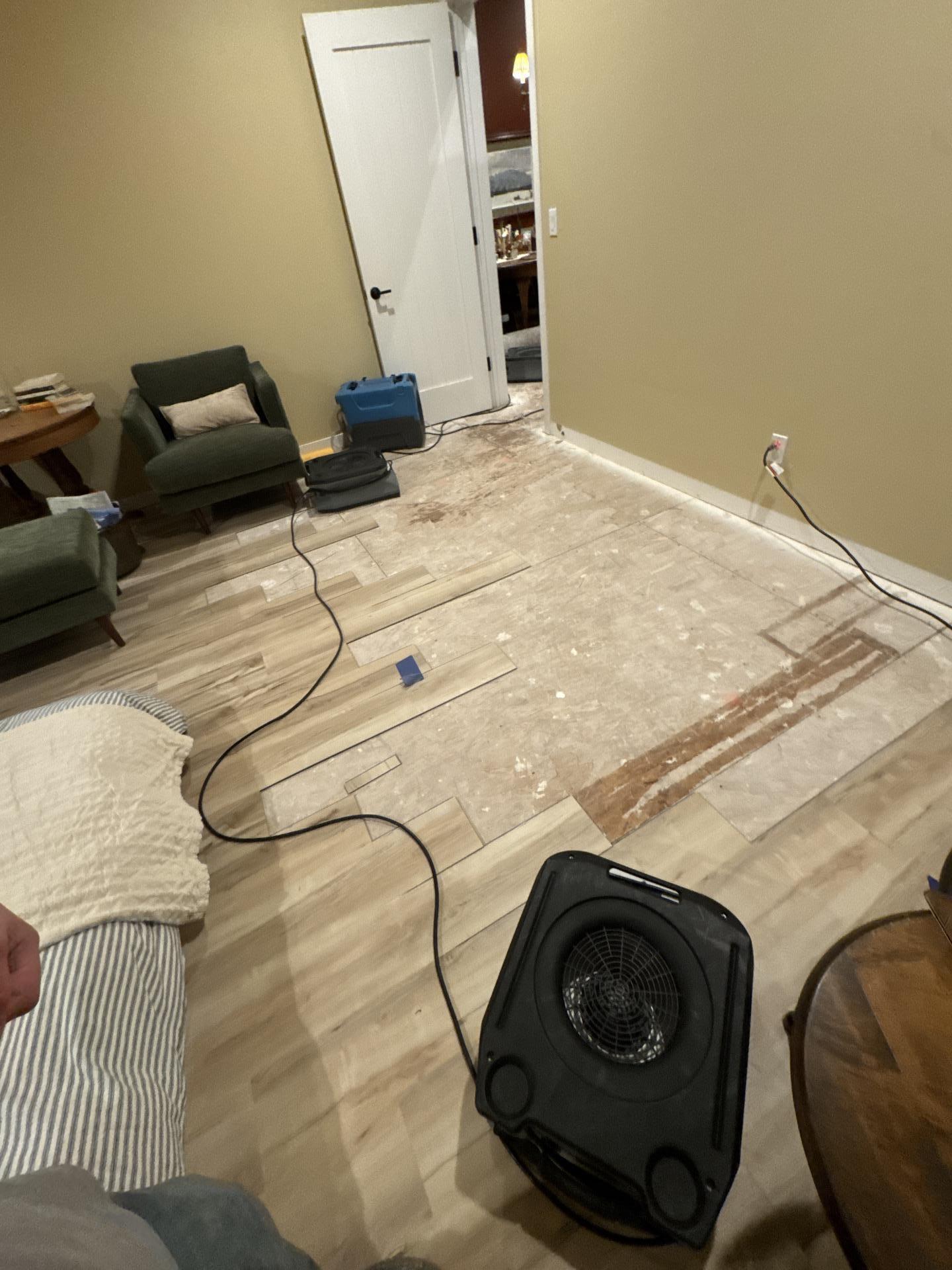Drying equipment running in bedroom with exposed subfloor after water damage mitigation