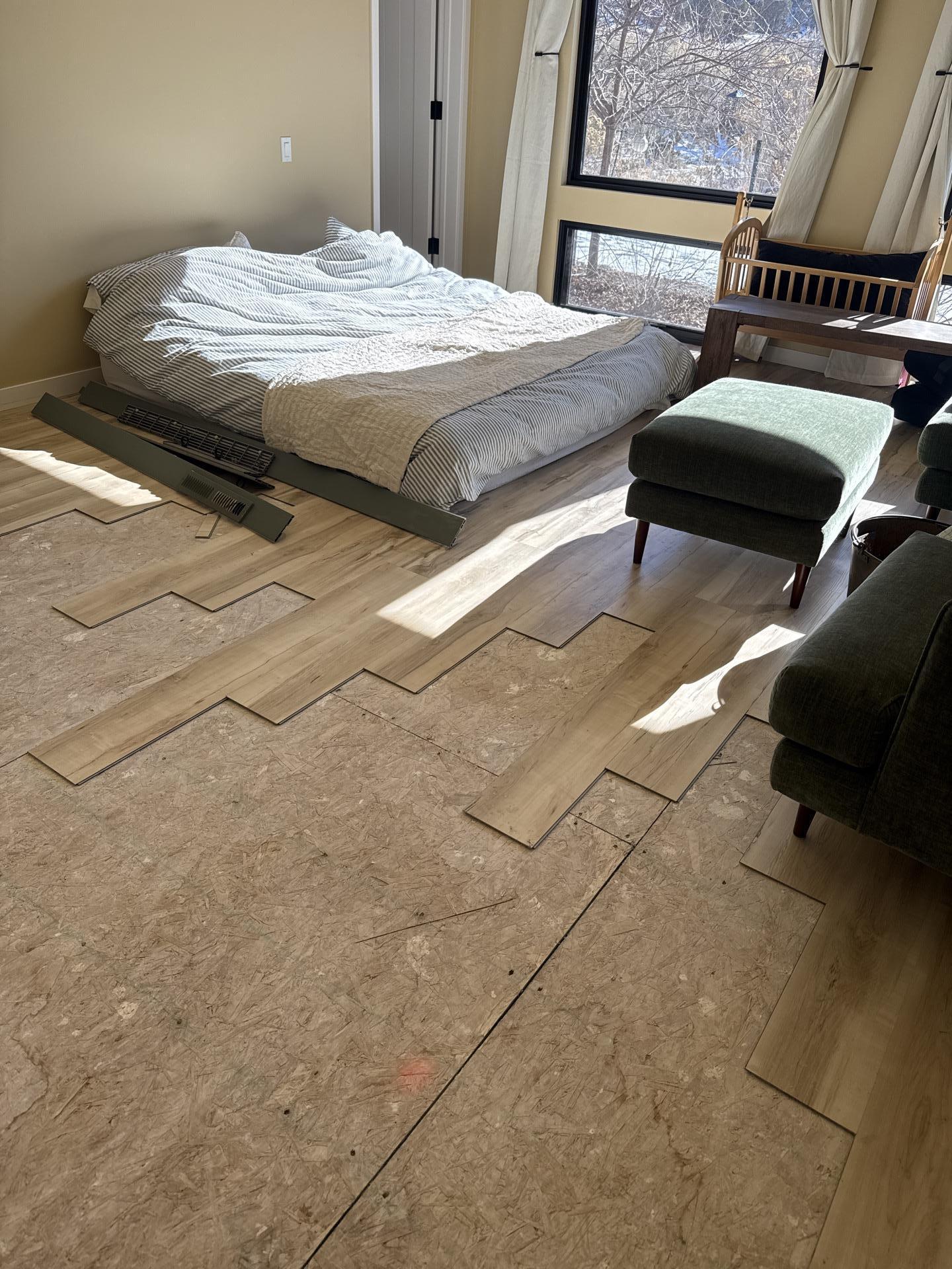 Moisture-damaged luxury vinyl plank flooring removed from bedroom adjacent to water loss area