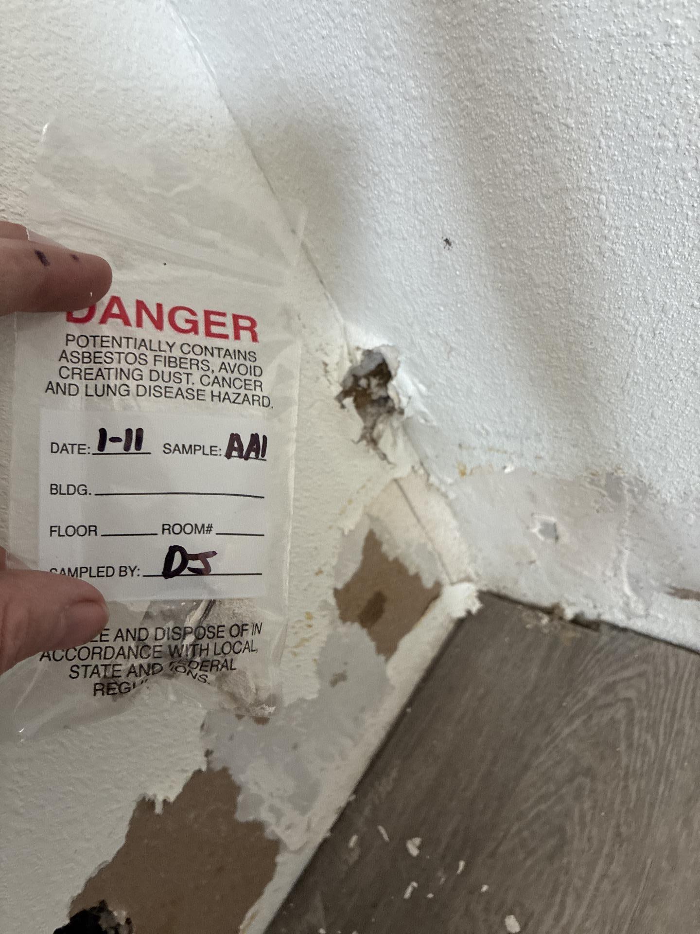 Asbestos test results reviewed on site before removal of affected drywall during water mitigation