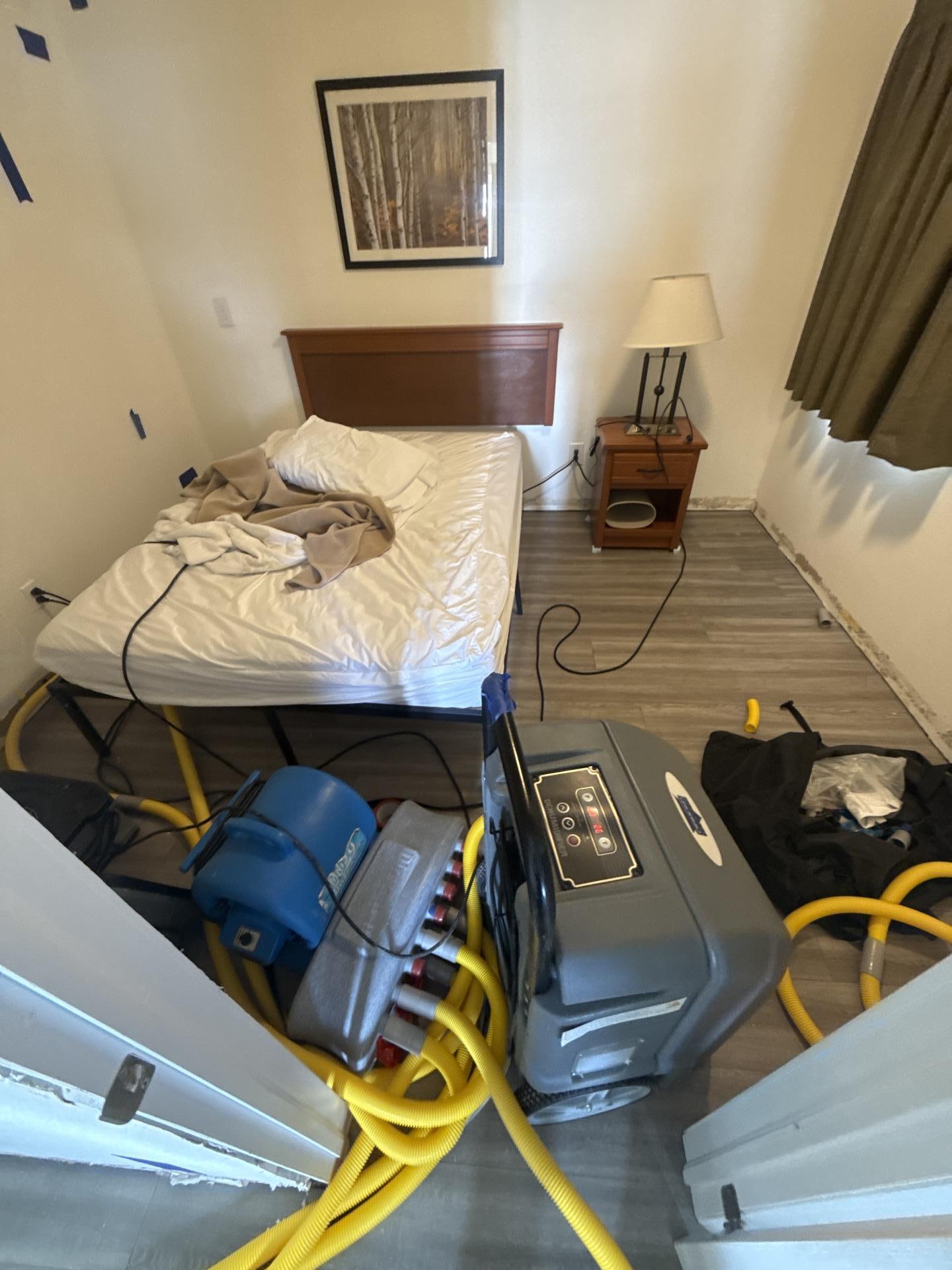 Bedroom drying setup with air movers placed and contents cleared for water damage restoration