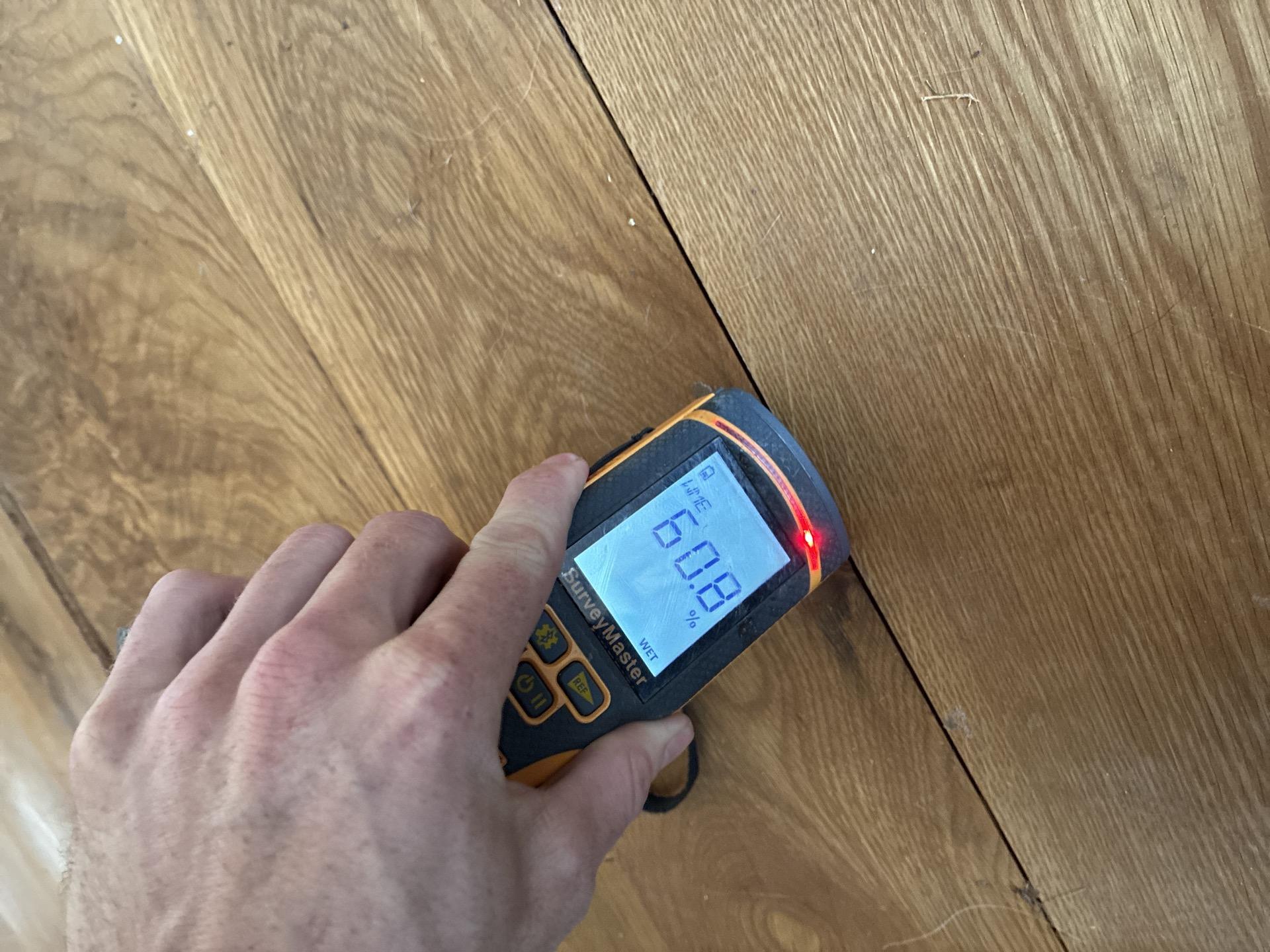 Buckled hardwood kitchen flooring lifting off the subfloor after a water loss