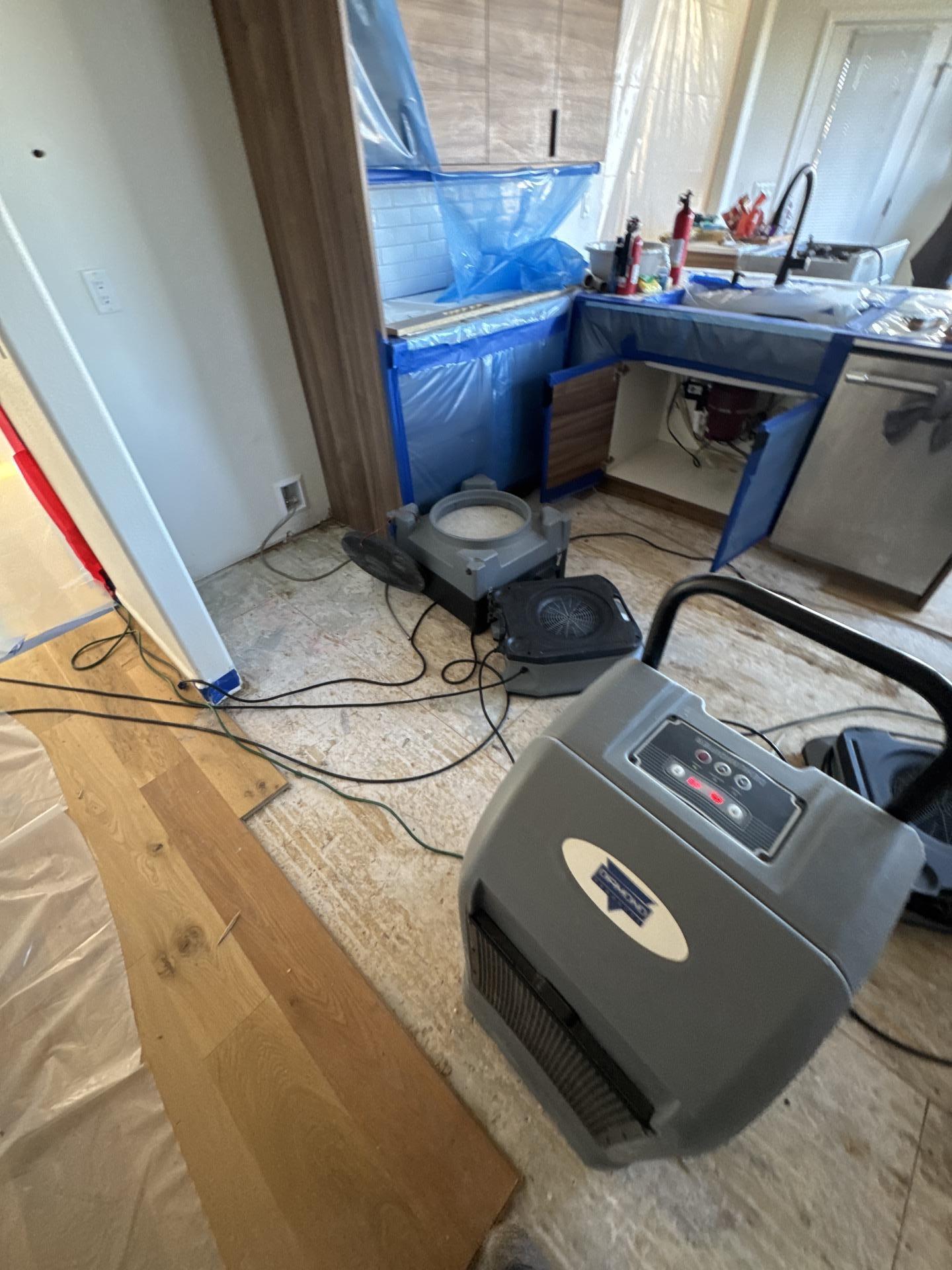 Kitchen water damage restoration in progress after flooring removal