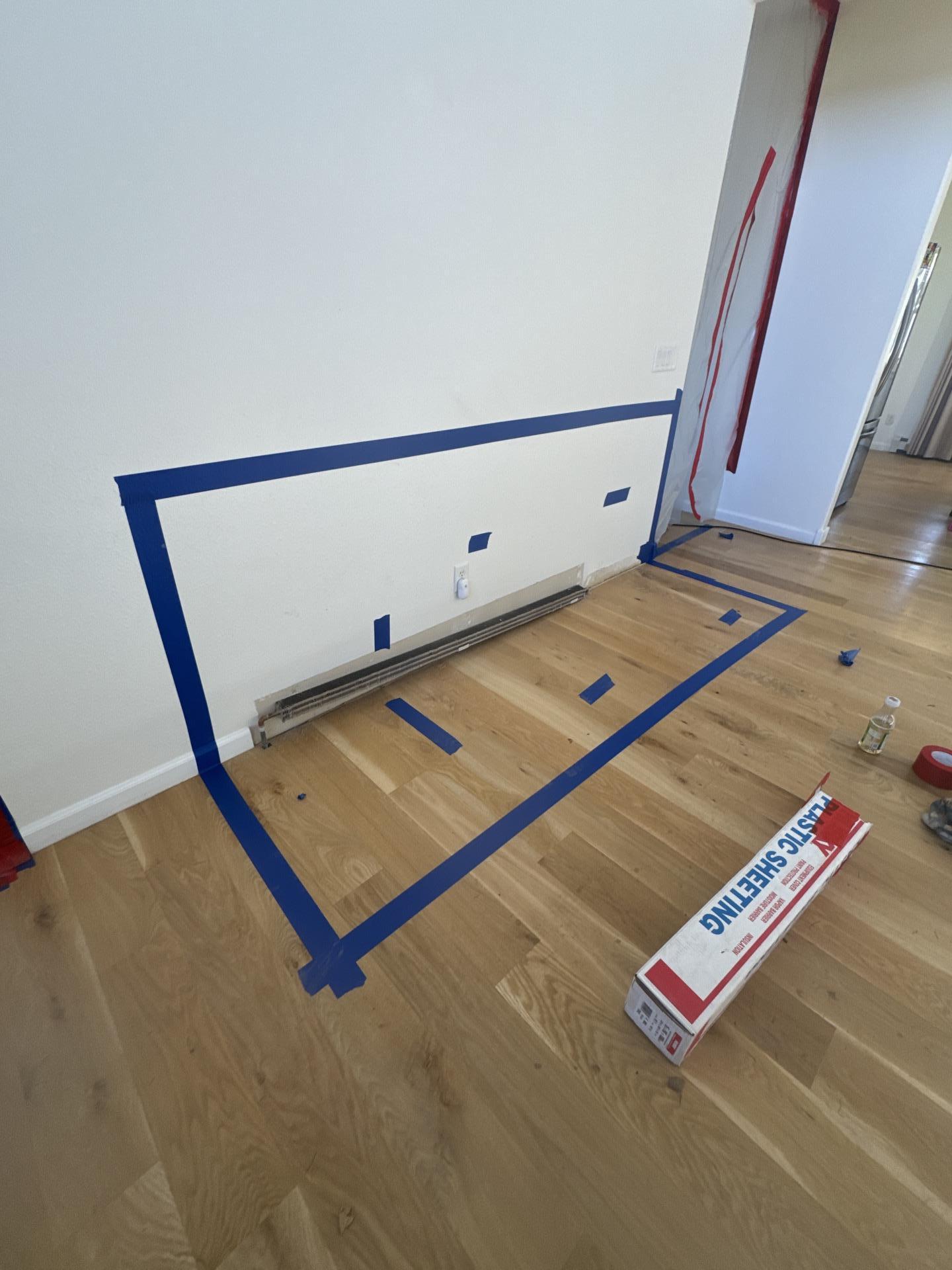 Technician mapping moisture migration in the living room next to the refrigerator wall