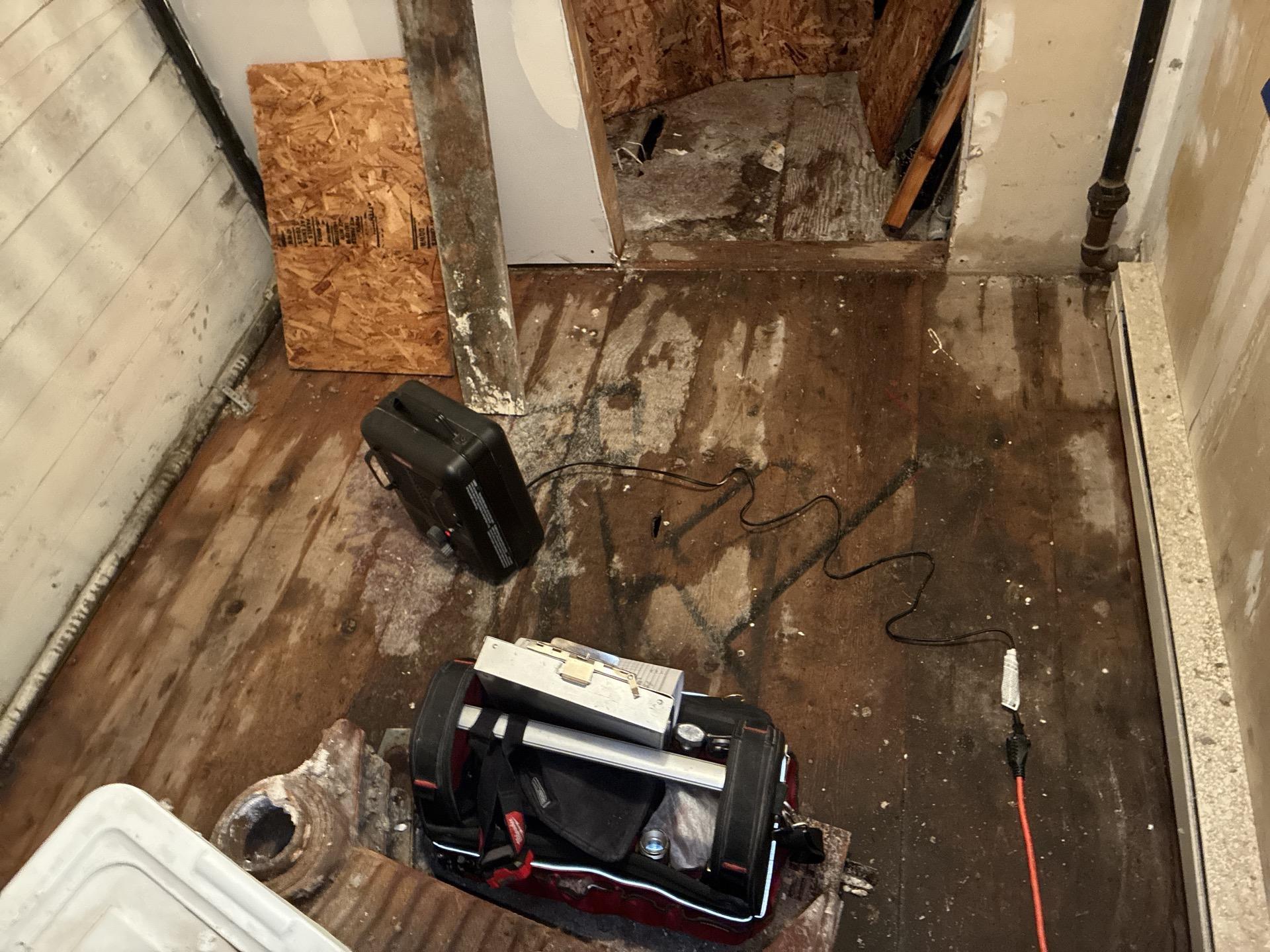 Storage room water damage cleanup in progress with contents cleared and drying equipment running