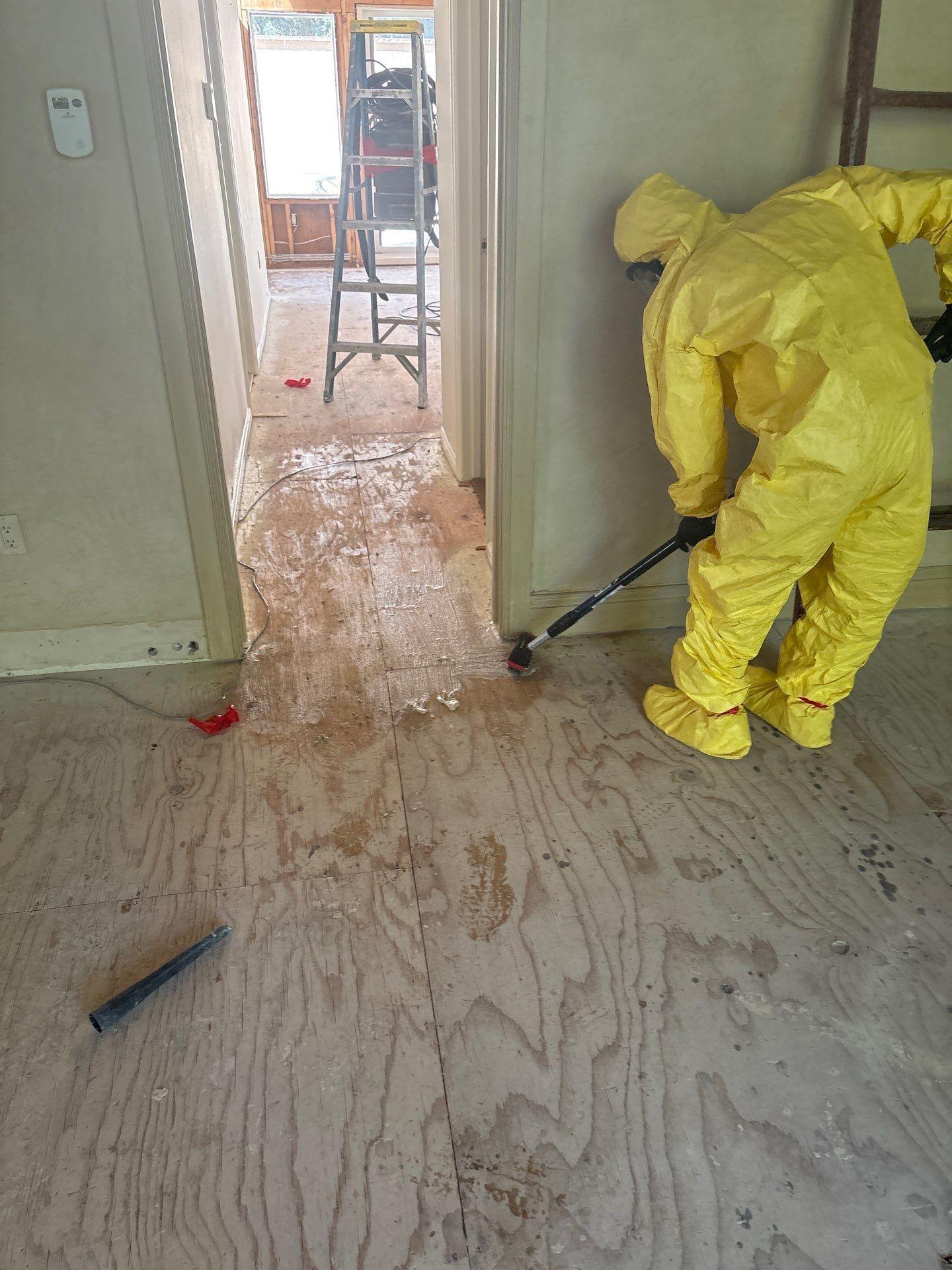 Crew member wearing a respirator and protective suit while removing mold