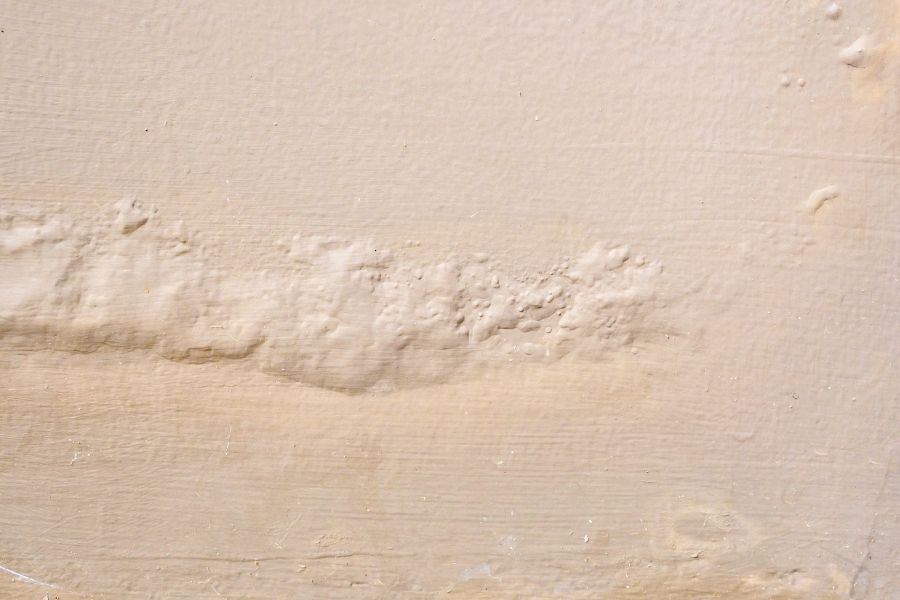 Bubbling and blistering paint on a wall caused by trapped water damage