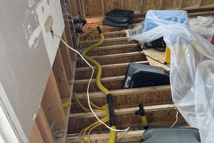 Air movers and dehumidifier drying a room after damaged materials were removed