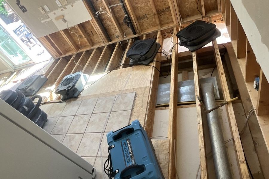 Air movers and dehumidifiers set up for structural drying in a water damaged home