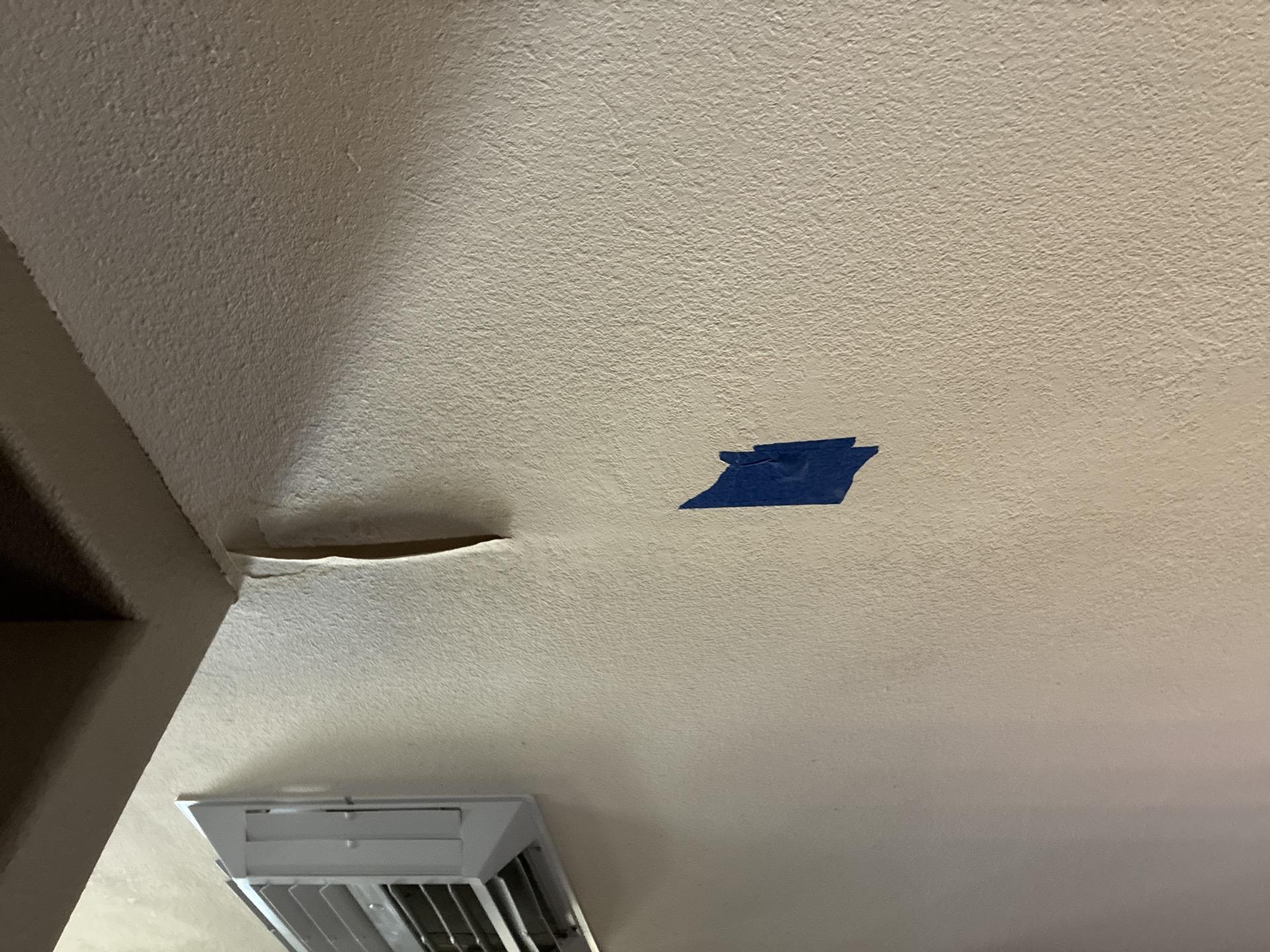 Living room ceiling with seam tape delamination and paint chipping from a prior roof leak