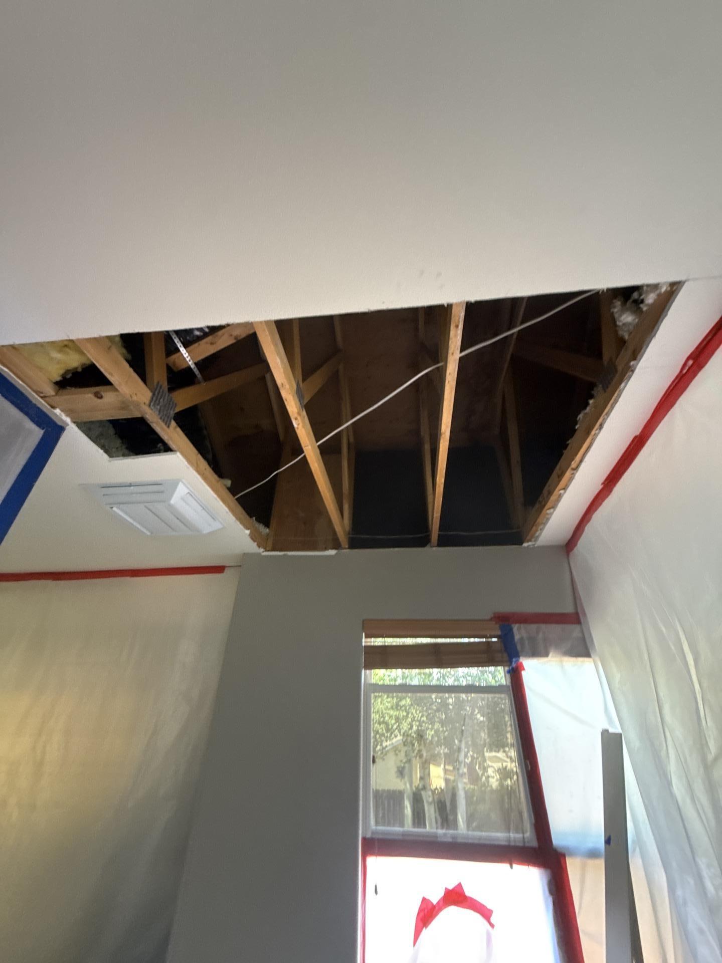 Open wall and ceiling cavity revealing concealed water damage during demolition