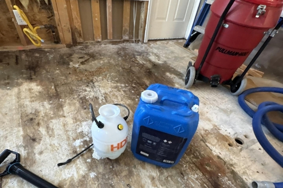 Water damage restoration in progress with exposed wall studs and subflooring drying after a burst pipe